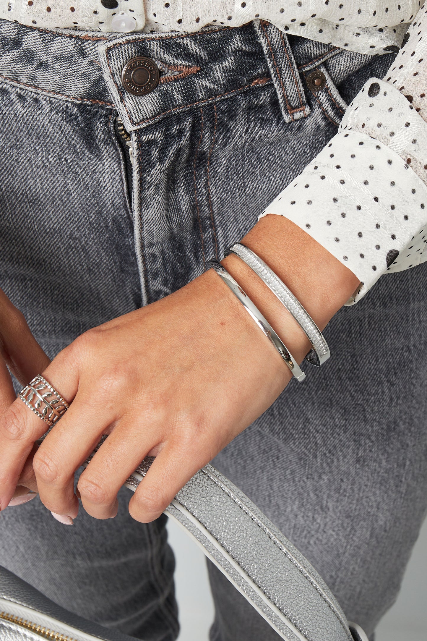Silver hammered-effect wide cuff bracelet worn on the wrist, Elara bracelet from Sorea Fashion.