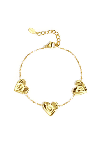 Gold bracelet with dangling heart-shaped charms displayed on a white background from Sorea Fashion.