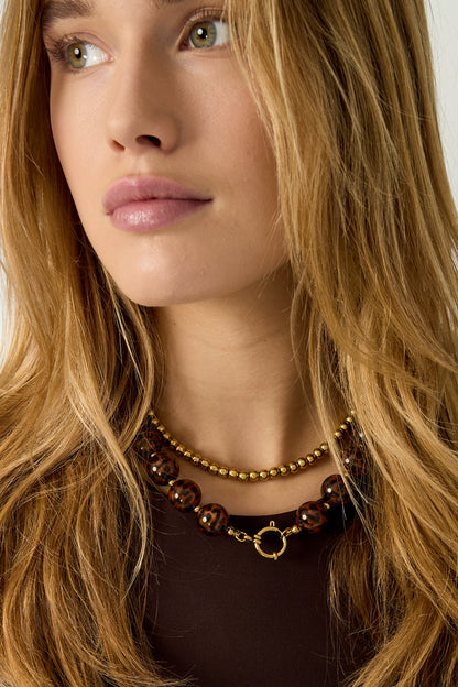 Gold Lea necklace with a round pendant worn layered with another necklace from Sorea Fashion.