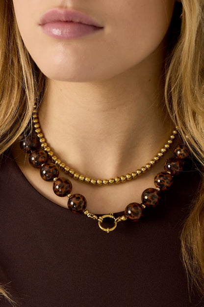 Gold Lea necklace with a round polished pendant worn around the neck from Sorea Fashion.