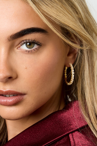 Gold minimalist hoop earrings worn in the ear, featuring a sleek polished finish, from Sorea Fashion.