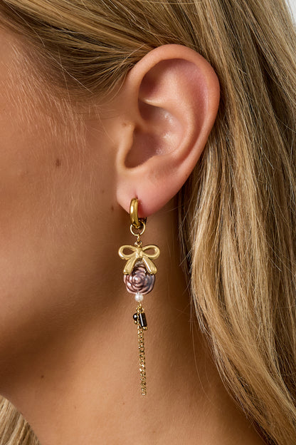 Gold Rosey earrings with small rose-shaped design worn in the ear from Sorea Fashion.